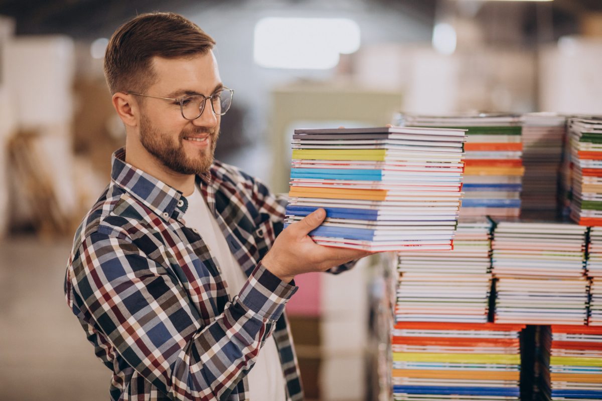 Man working in printing house with paper and paints